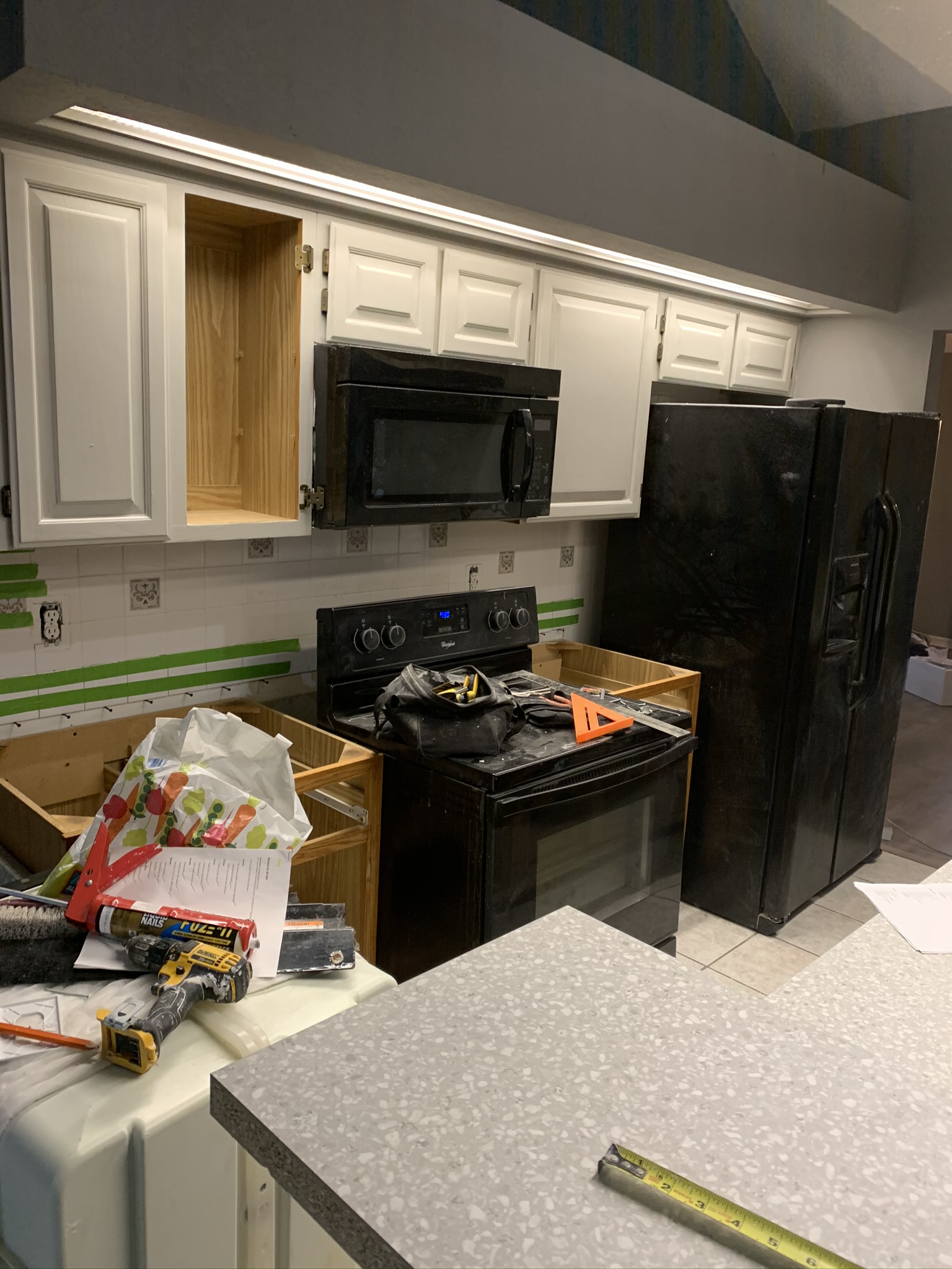 Kitchen remodel in progress with cabinets removed and appliances staged