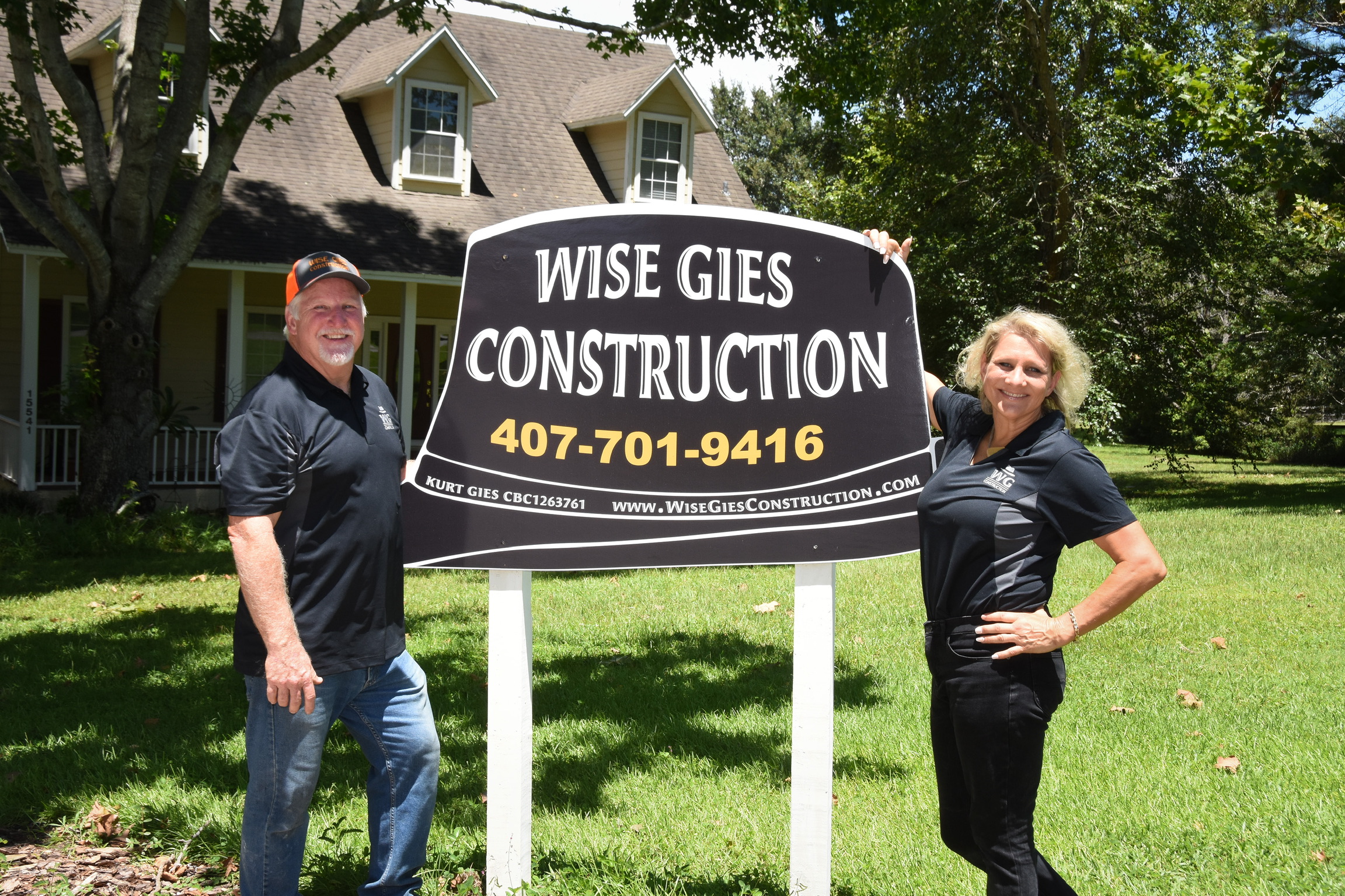 Kurt and Lana Gies beside a Wise Gies Construction yard sign